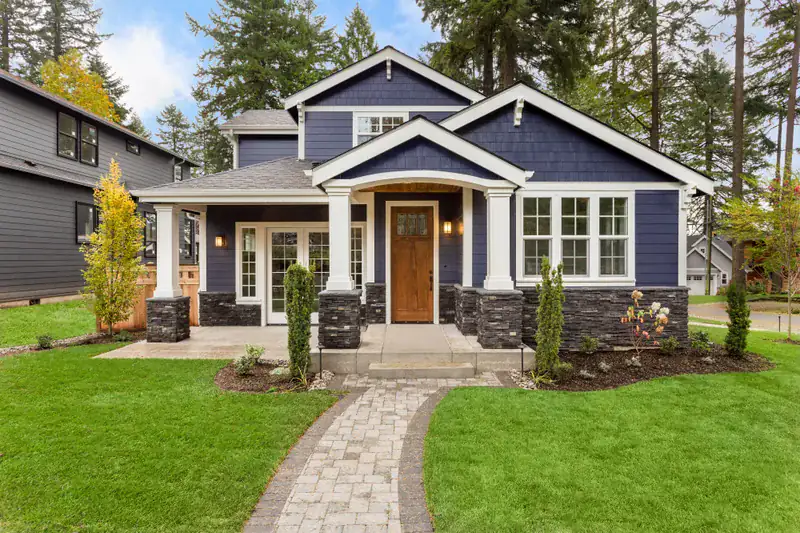 A craftsman home with the porch lanterns lit